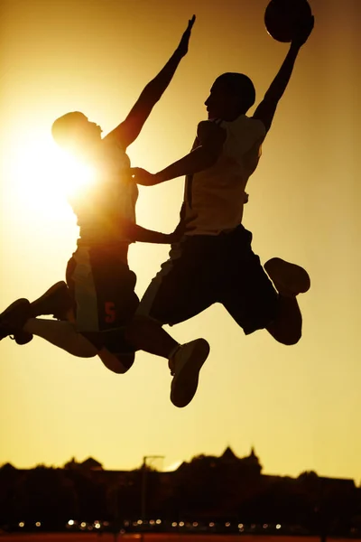 Botsing van de Titanen. Twee basketbalspelers spelen bij zonsondergang. — Stockfoto