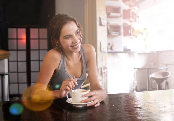 Café peut mettre un sourire sur n'importe quel visage. Plan d'une jeune femme buvant du café dans un café. — Photo