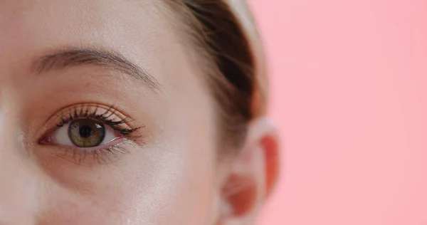 Yo espío con mi pequeño ojo. Retrato de estudio recortado de un ojo de mujer joven sobre un fondo rosa. —  Fotos de Stock