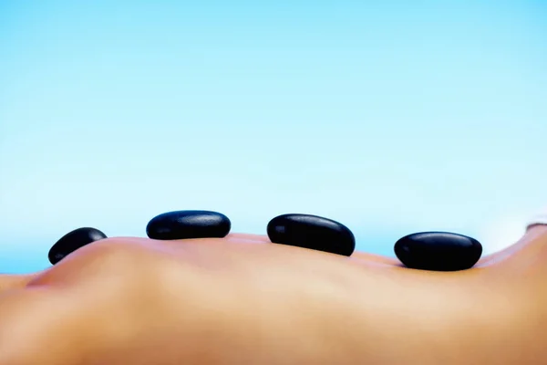 Femme se faire masser la pierre chaude dans le spa de jour avec copyspace. Femme obtenir un massage aux pierres chaudes dans le spa de jour avec de la place pour votre texte. — Photo