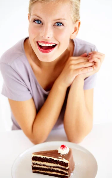 For me It looks delicious. Smiling young woman looking forward to a delicious piece of chocolate cake. — Stock Photo, Image