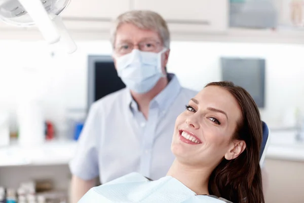Wizyta u dentysty. Portret uśmiechniętego pacjenta z dojrzałym lekarzem w klinice. — Zdjęcie stockowe