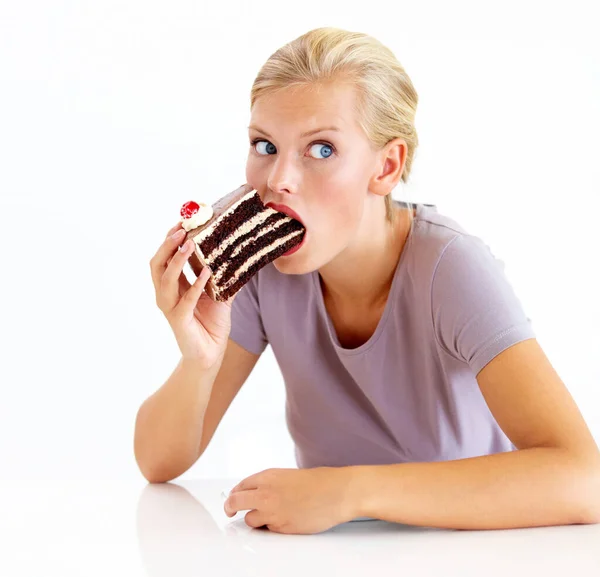 I hope no one sees me cheating - Dieting. Young woman stuffing her mouth full of chocolate cake. Stock Photo