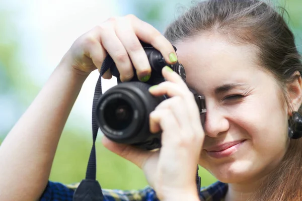 Zoomen, um eine gute Aufnahme zu bekommen. Eine schöne junge Frau macht ein Foto mit ihrer Kamera. — Stockfoto