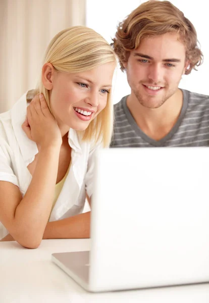 Συνομιλία με φίλους μέσω του διαδικτύου. Ένα ευτυχισμένο νεαρό ζευγάρι που χρησιμοποιεί ένα φορητό υπολογιστή για να περιηγηθεί στο διαδίκτυο. — Φωτογραφία Αρχείου