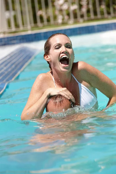 Cabeza mojada. Tiro de una pareja feliz siendo juguetona en la piscina. — Foto de Stock