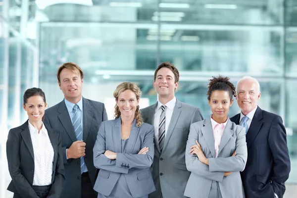 Zespół, na którym możesz polegać. Pewna siebie grupa biznesmenów stojąca razem i uśmiechnięta - portret. — Zdjęcie stockowe