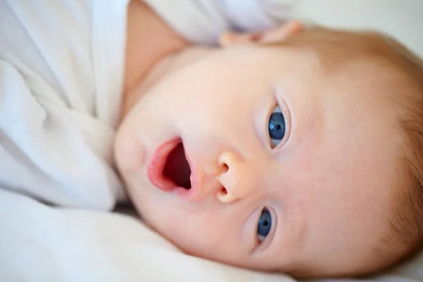 Olhando para um mundo de maravilhas. Retrato de perto de um recém-nascido adorável deitado em um berço. — Fotografia de Stock