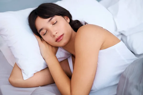 Похоже, спит. Выстрел уставшей привлекательной молодой женщины, спящей в своей постели дома утром. — стоковое фото