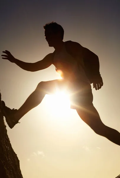 Cuando la aventura llama... contesta. Una silueta de un hombre saltando sobre rocas. —  Fotos de Stock