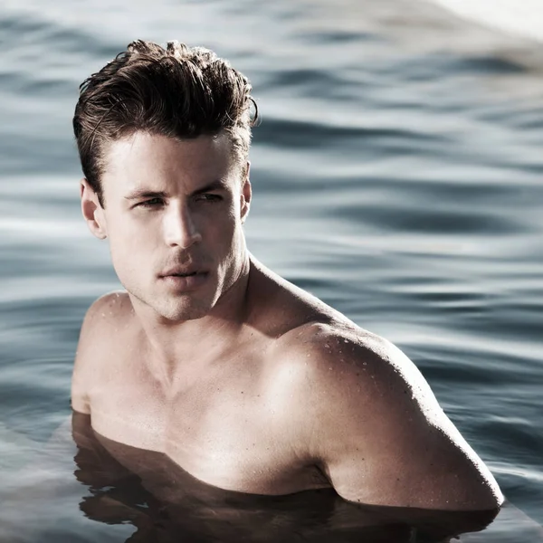 Chwilę dla siebie. Przystojny mężczyzna modelka w wodzie spogląda w bok. — Zdjęcie stockowe