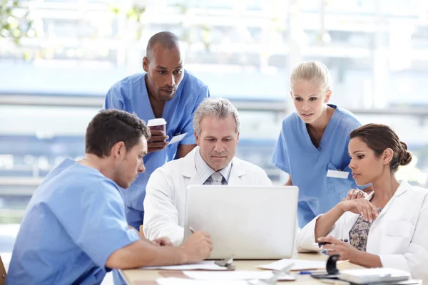Vyhrazený tým zdravotnických pracovníků. Tým lékařů pracujících kolem notebooku. — Stock fotografie