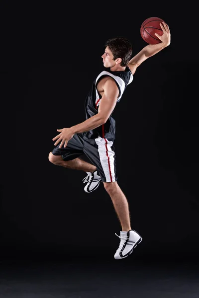 Dia punya kekuatan super basket. Foto profil lengkap dari pemain basket laki-laki muda yang beraksi melawan latar belakang hitam. — Stok Foto