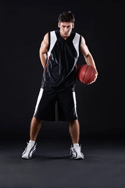 Perder no es una opción. Retrato completo de un jugador de baloncesto masculino en acción sobre un fondo negro. — Foto de Stock