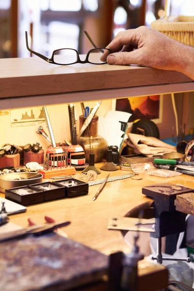 Necesidad de una visión perfecta para el buen trabajo por delante. Vista recortada de un artesano que busca sus gafas en su puesto de trabajo. — Foto de Stock