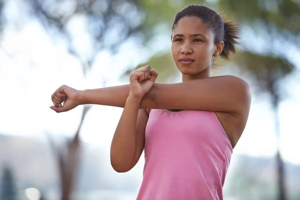 Sicherstellen, dass ihre Muskeln für den Lauf bereit sind. Ein junger Teenager wärmt sich für die Zukunft auf. — Stockfoto