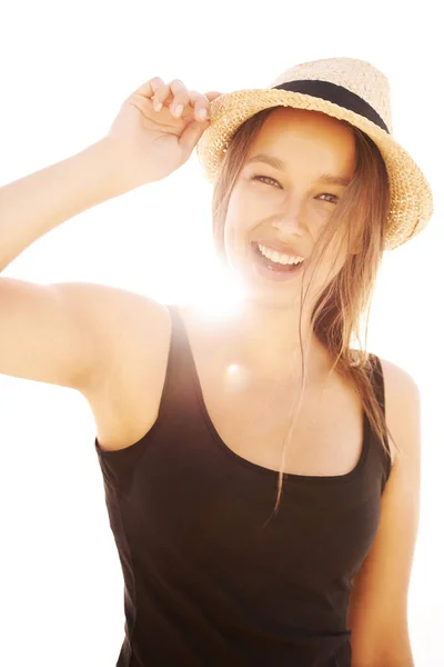 Пам'ятай сонцезахисний крем. Грайлива молода жінка тримає капелюх у яскравому сонячному світлі . — стокове фото