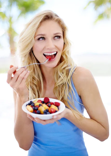 Uma dieta que ela pode desfrutar. Mulher bonita apreciando sua salada de frutas. — Fotografia de Stock