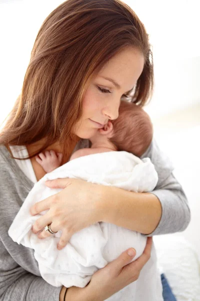 Moje malé děťátko. Shot of a young mother holding her newborn baby girl in her arms. — Stock fotografie