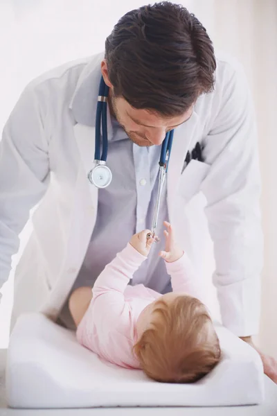 Zijn kleine patiënt ontmoeten. Een mannelijke arts die een baby patiënt bijstaat. — Stockfoto