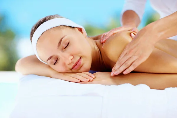 Jovencita relajada recibiendo masaje en el hombro de una masajista. Relajada joven mujer recibiendo masaje en el hombro de un masajista profesional. — Foto de Stock