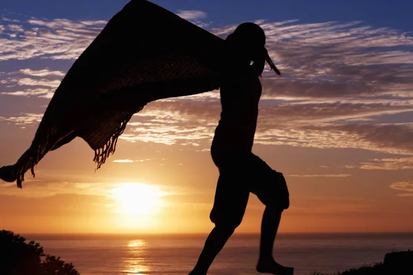 Nő fut. Egy nő sziluettje, aki napkeltekor takaróval rohangál.. — Stock Fotó