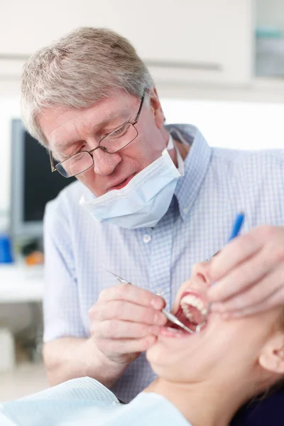 Para tener mejores dientes. Retrato de paciente femenina con dentista trabajando en sus dientes. — Foto de Stock