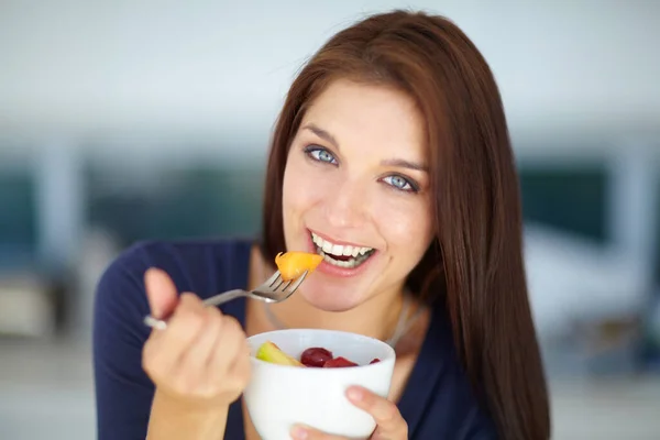 おいしい、健康的なスナックに飲み込まれます。ランチに健康的なフルーツサラダを食べる笑顔の若い女性の肖像画. — ストック写真
