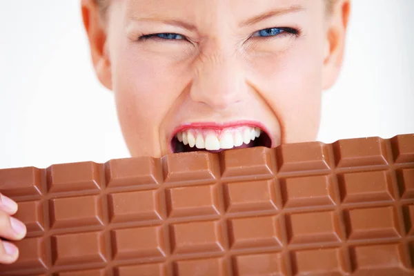 Devo mangiarlo tutto. Pazzo giovane donna mordere un enorme pezzo di cioccolato. — Foto Stock