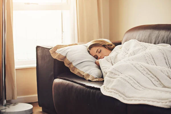 Finns det något bättre än en lat eftermiddagslur? Skjuten av en ung kvinna sover lugnt på soffan hemma. — Stockfoto