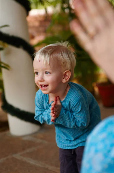 Learning the ways of tradition. Cute little boy adorned with a bindi on his forehead, bowing in a Hindu temple. — Stock Photo, Image
