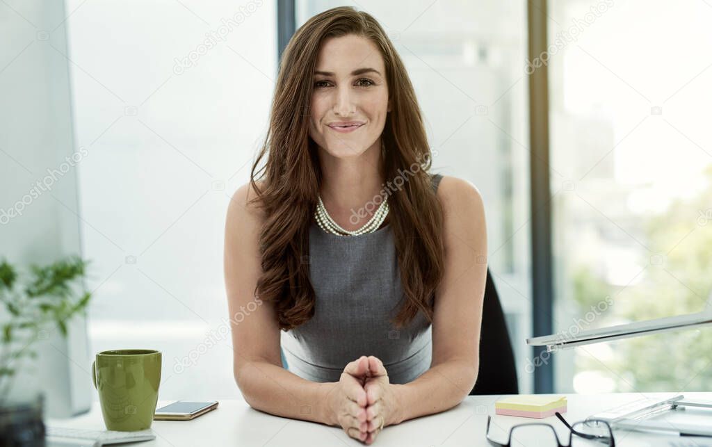 Shes a self made success. Portrait of a young businesswoman sitting at her desk in an office.