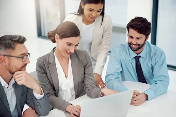 Redéfinir leur proposition. Plan d'un groupe d'hommes d'affaires travaillant ensemble dans un ordinateur portable dans un bureau moderne. — Photo