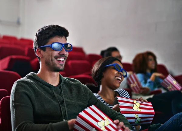 Las emociones y los derrames nunca se veían tan bien. Fotografía de un hombre y una mujer riendo mientras ven una película en 3D en el cine. —  Fotos de Stock