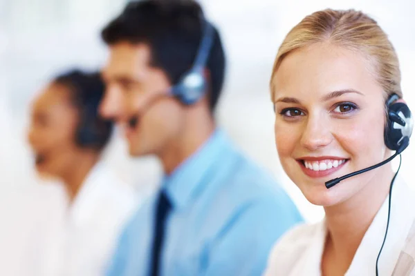 Servicio con sonrisa. Primer plano del operador femenino profesional sonriendo en el centro de llamadas. — Foto de Stock