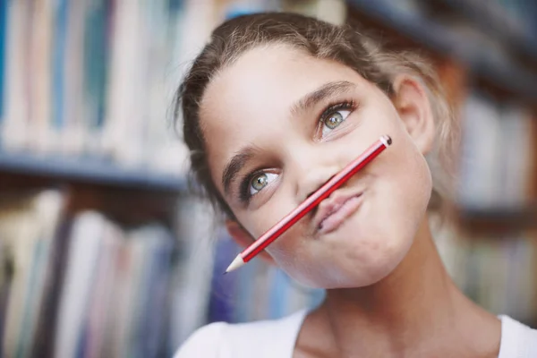 Классовый клоун. Милая молодая девушка, балансирующая карандашом на губах и корчащая рожу. — стоковое фото