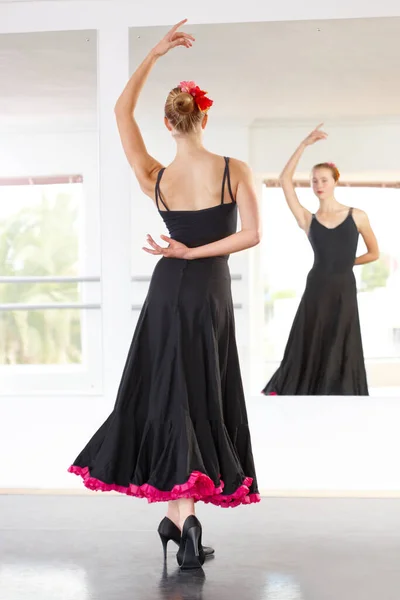Carefully controlled passion. Young dancer performing flamenco in a dance studio.