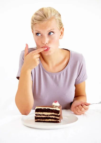 小さな味を試してみる...チョコレートケーキのおいしい作品の霜降りを味わう若い女性. — ストック写真