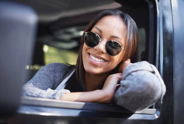 Jag njuter bara av åkturen. En ung etnisk kvinna ler när hon tittar ut genom ett bilfönster. — Stockfoto