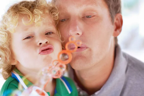 Bolhas de diversão. Um pai e um filho soprando bolhas juntos. — Fotografia de Stock