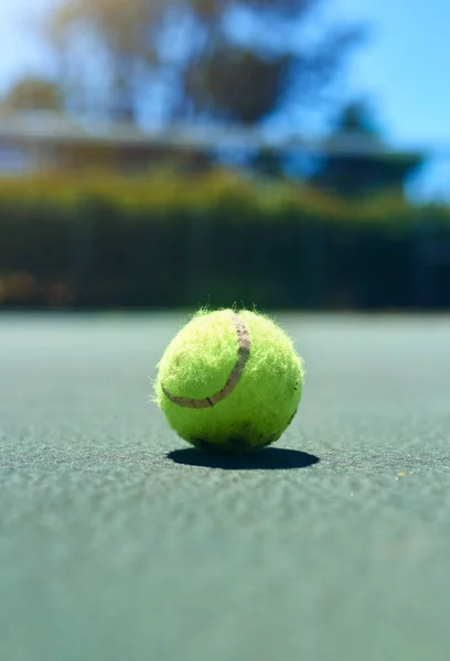 Lasst die Spiele beginnen. Schnappschuss eines Tennisballs auf einem leeren Platz während des Tages. — Stockfoto
