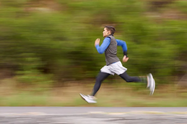 マイルを燃やせ。道路を走っている若い男の動きのぼやけたイメージ. — ストック写真