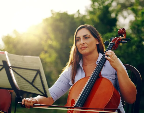 La musica è qualcosa che si sente e si sente. Colpo ritagliato di una bella donna che suona un violoncello nel cortile. — Foto Stock