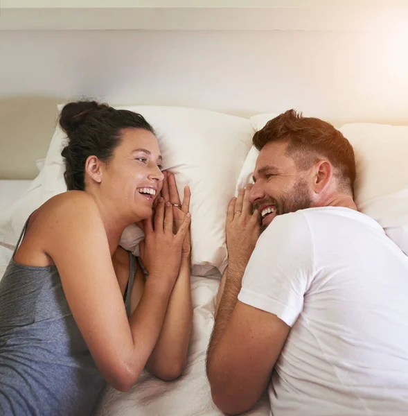 Es ist immer Lachen und Glück, wenn es um sie geht. Schnappschuss eines jungen attraktiven Paares, das zu Hause zusammen im Bett liegt. — Stockfoto