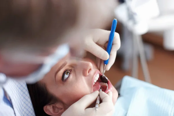 Paciente dentista visitante. Vista de ángulo alto del dentista que revisa los dientes de los pacientes. — Foto de Stock