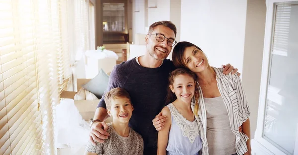 Welkom in ons nieuwe huis. Portret van een gelukkig gezin samen in hun nieuwe huis. — Stockfoto