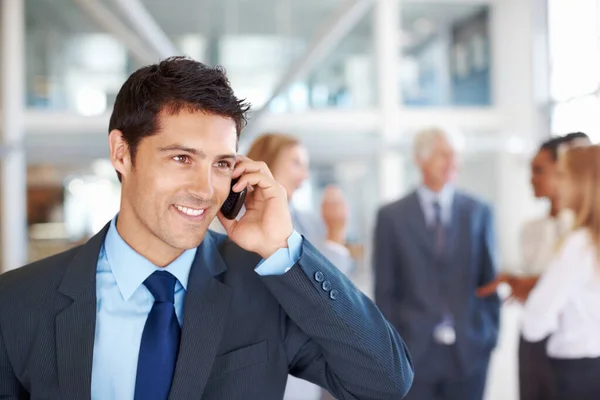 Male executive on call with team discussing. Portrait of smart male executive on call with business team discussing in background. — Stock Photo, Image