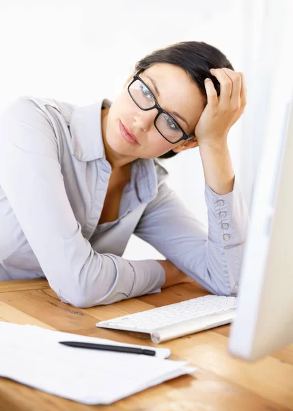 Gelangweilt von ihrer Firmenroutine. Gelangweilte junge Geschäftsfrau sitzt an ihrem Schreibtisch. — Stockfoto