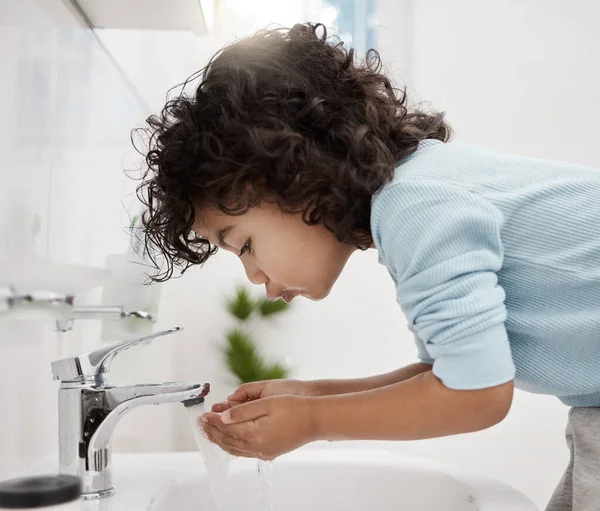 Temiz ve taze kalmak. Evdeki bir banyoda ellerini ve ağzını yıkayan sevimli bir çocuğun fotoğrafı.. — Stok fotoğraf