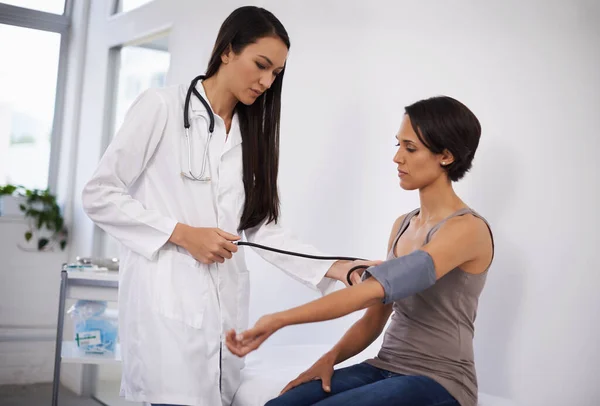 Érzek egy kis teljesítménynyomást. Egy fiatal nő vérnyomását mérte meg egy orvos.. — Stock Fotó